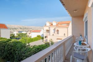 a balcony with a view of a house at Apartment Wish - two bedrooms with 2 AC renewed in Pag