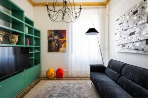 a living room with a couch and a television at Libertà 78 - Art Suite & Spa in Palermo