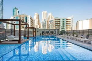 a large swimming pool with chairs and buildings at Frank Porter - Studio One in Dubai