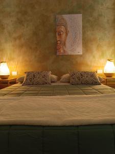 een bed met twee kussens en een schilderij aan de muur bij Pangea in Trani