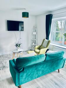 a living room with a green couch and two chairs at Dover Castle Luxury Apartments in Kent