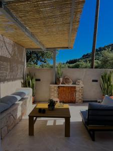 a patio with a couch and a table at Armando Cottage - Private Nature Retreat with BBQ to Experience Magical Greek Hospitality By Villa Mana Gers in Pandokrátor +44 photos