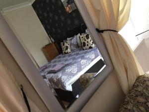 a small bedroom with a bed and a mirror at Manor House Hotel in Thurso
