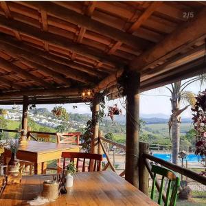 a wooden table and chairs on a porch with a view at Pousada Rural em Braganca Paulista in Bragança Paulista