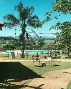 a park with a table and chairs and a roller coaster at Pousada Rural em Braganca Paulista in Bragança Paulista