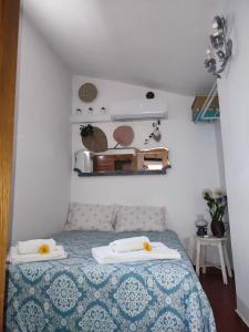 a bedroom with a bed with a blue and white bedspread at 10 da Muralha in Estremoz