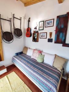 a bedroom with a bed with a guitar on the wall at 10 da Muralha in Estremoz