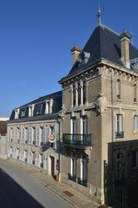 un grand bâtiment avec une horloge sur son côté dans l'établissement Hotel Castel Jeanson, à Ay