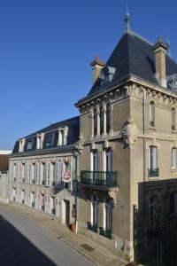 a large building with a clock on the side of it at Hotel Castel Jeanson in Ay