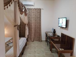 a hotel room with a desk and a bed and a television at 1001-Nights Palace 