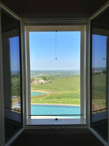 een raam in een kamer met uitzicht op een meer bij Podere Mantignano in Faenza