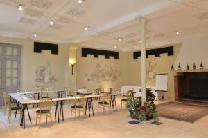 une grande salle à manger avec une table et des chaises dans l'établissement Hotel Castel Jeanson, à Ay