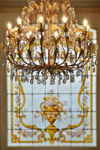 a chandelier is hanging in front of a window at Hotel Castel Jeanson in Ay