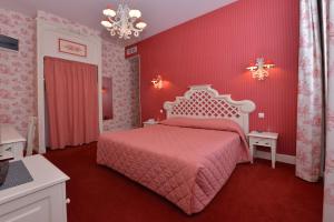 une chambre rose avec un lit et des murs roses dans l'établissement Hotel Castel Jeanson, à Ay