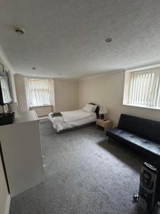 a living room with a bed and a couch at Manor House Hotel in Thurso