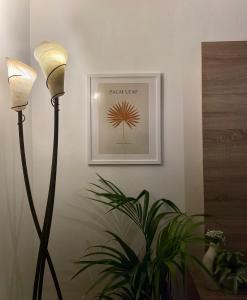 due lampade a pavimento e una pianta in una stanza con un quadro di The Meadows Hideaway a Doolin