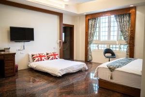 a bedroom with two beds and a flat screen tv at 宜蘭 星居 包層公寓 in Yilan City