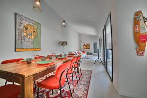uma sala de jantar com uma mesa de madeira e cadeiras vermelhas em Villa de Rêve à La Tremblade - Piscine chauffée em La Tremblade