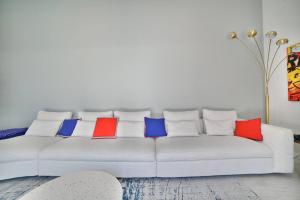 um sofá branco com quatro almofadas coloridas em Villa de Rêve à La Tremblade - Piscine chauffée em La Tremblade