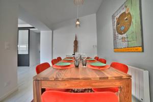 uma sala de jantar com uma mesa de madeira e cadeiras vermelhas em Villa de Rêve à La Tremblade - Piscine chauffée em La Tremblade