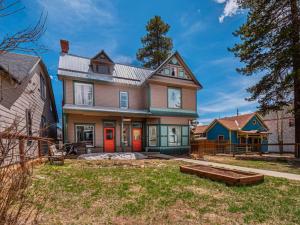 a large house with red doors and a yard at Governor's Mansion beautiful 3bd with pool table in Leadville