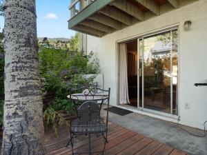 a chair sitting on a deck next to a tree at Relaxing 2 Bedroom steps from Vail Resort in Vail