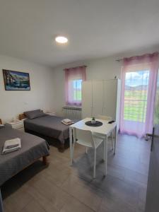 a living room with a bed and a white table at Apartman Marija in Perušić