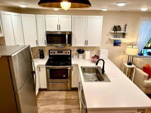a kitchen with white cabinets and a stainless steel refrigerator at Leadville's Copper Top Getaway in Leadville