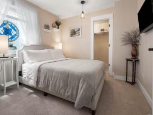 a white bedroom with a bed and a television at Leadville's Copper Top Getaway in Leadville +19 photos