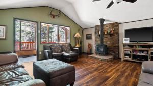 - un salon avec un canapé et une cheminée dans l'établissement The Whispering Pines Cabin, à Leadville