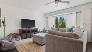 a living room with a couch and a flat screen tv at Mountain Home with Amazing Views and Hot Tub in Leadville