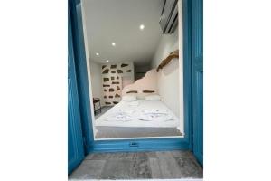 een kleine kamer met een bed in een blauw frame bij Politimis Studio N2 in Amorgós