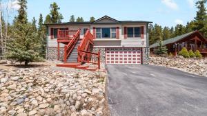 a house with a staircase in front of a driveway at Mountain Home with Amazing Views and Hot Tub in Leadville