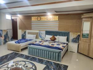 a bedroom with two beds in a room at Al Wasay Hotel in Rawalpindi