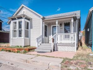 a white house with a white porch and stairs at Stylish 1BR Airbnb in Leadville with Mountain Views - Near Skiing - Pets okay in Leadville