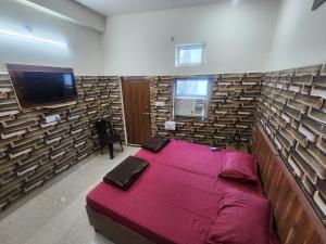 sypialnia z dużym łóżkiem i telewizorem w obiekcie Radha Rani Dham (Near Iskcon Temple) w mieście Wryndawan