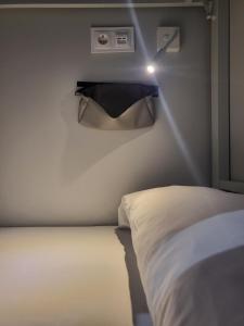 1 dormitorio con 1 cama y una luz en la pared en Acolá Sport Hostel, en Pontevedra