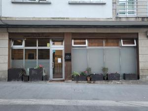 een winkel voor een gebouw met potplanten bij Acolá Sport Hostel in Pontevedra