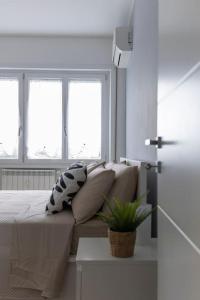 ein weißes Zimmer mit einem Sofa und 2 Fenstern in der Unterkunft Luminous Home Roma Trastevere in Rom