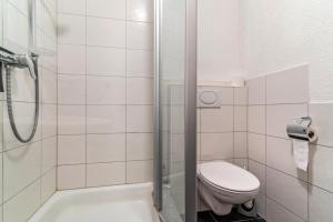 Un baño blanco con inodoro y ducha. en Ferienwohnung Lehen - Herr 1, en Freiburg im Breisgau