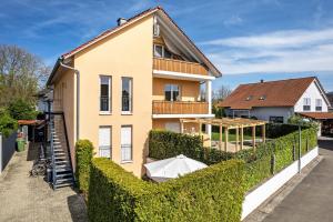 una casa con un seto delante de ella en Ferienwohnung Lehen - Herr 1, en Freiburg im Breisgau