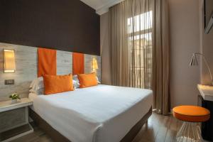 a bedroom with a large white bed with orange pillows at The Guardian in Rome
