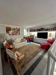 a living room with a couch and a tv at Pietrasantamare in Marina di Pietrasanta