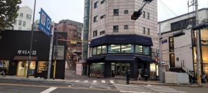 een drukke straat met gebouwen en een persoon die een straat oversteekt bij 4min to Seoul station 3R 2Bath in Seoul