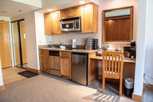 a kitchen with wooden cabinets and stainless steel appliances at Studio 521 Perfect Location with Pool and Hot Tub in Crested Butte