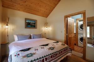 a bedroom with a bed and a washer and dryer at Little Lodge Leadville: charming 2bd in Leadville