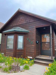 a wooden house with a porch and a door at Little Lodge Leadville: charming 2bd in Leadville