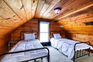 2 camas en una habitación con paredes de madera en New Listing - Tranquil Retreat with Hot Tub, en Des Moines