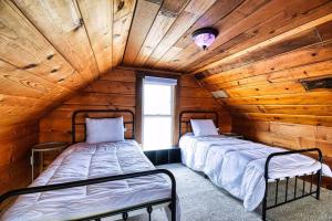 due letti in una stanza con pareti in legno di New Listing - Tranquil Retreat with Hot Tub a Des Moines