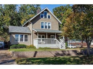 una casa marrón con un porche blanco y un árbol en New Listing - Tranquil Retreat with Hot Tub, en Des Moines